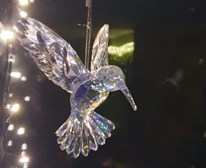 een vogel van glas verlicht bij kerstverlichting